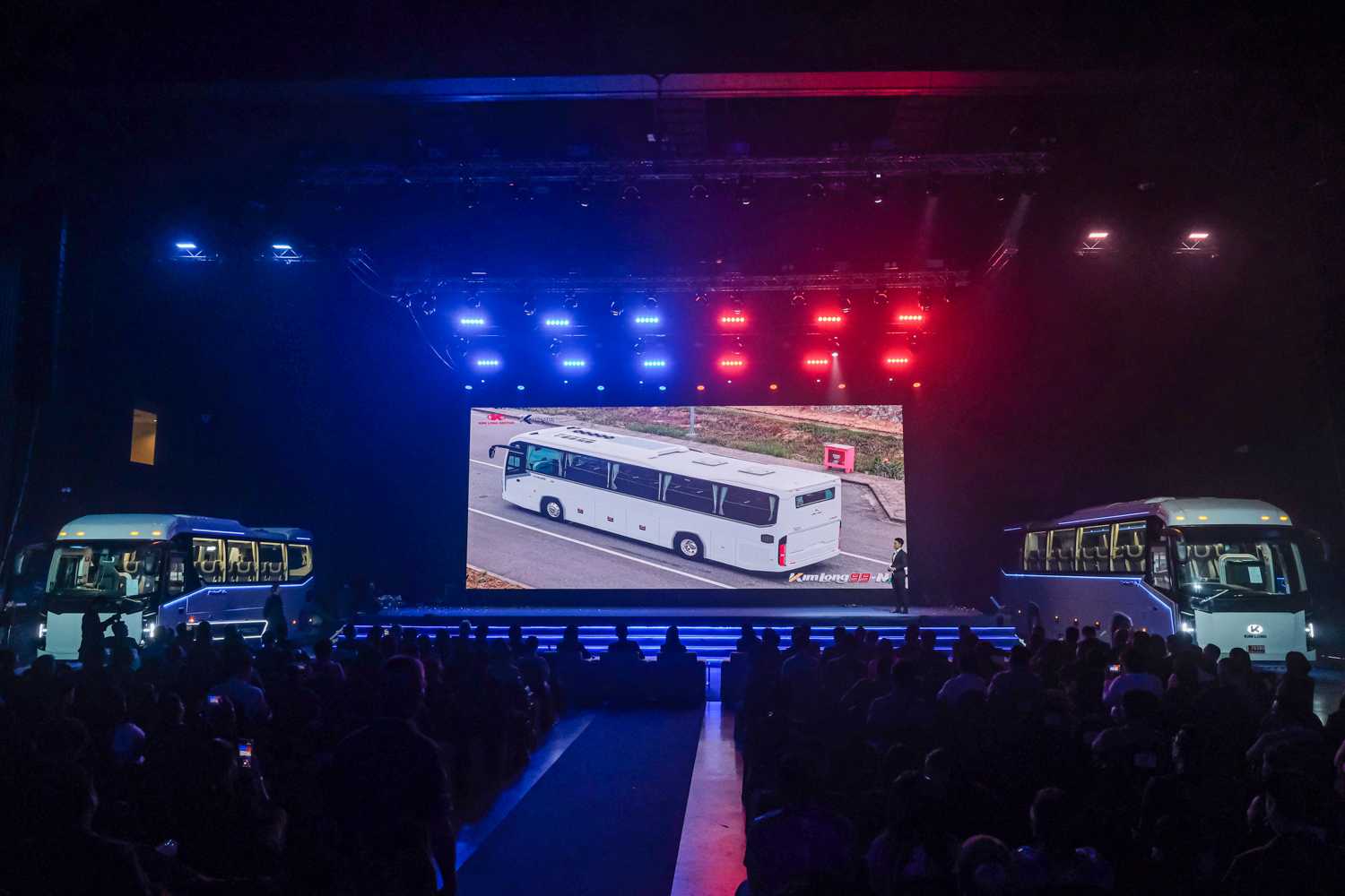 ภาพรวมฮอลล์และรถบัส KIM LONG MOTOR สองฝั่งเวทีงาน GRAND LAUNCH 2026